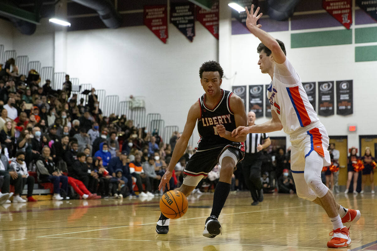 Liberty’s Dedan Thomas (11) drives around Bishop Gorman’s Ryan Abelman (0) during ...