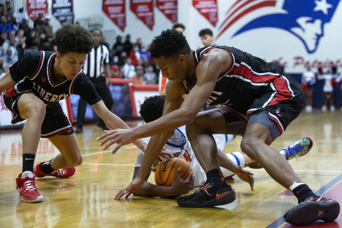 Liberty’s Angelo Kambala, left, and Joshua Jefferson, right, compete for the ball with B ...