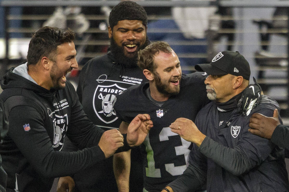Raiders interim head coach Rich Bisaccia, second from right, is congratulated by assistants and ...
