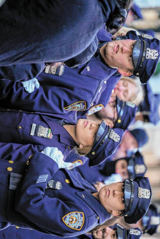 Police officers stand in line outside St. Patricks Cathedral to pay their respects during the w ...