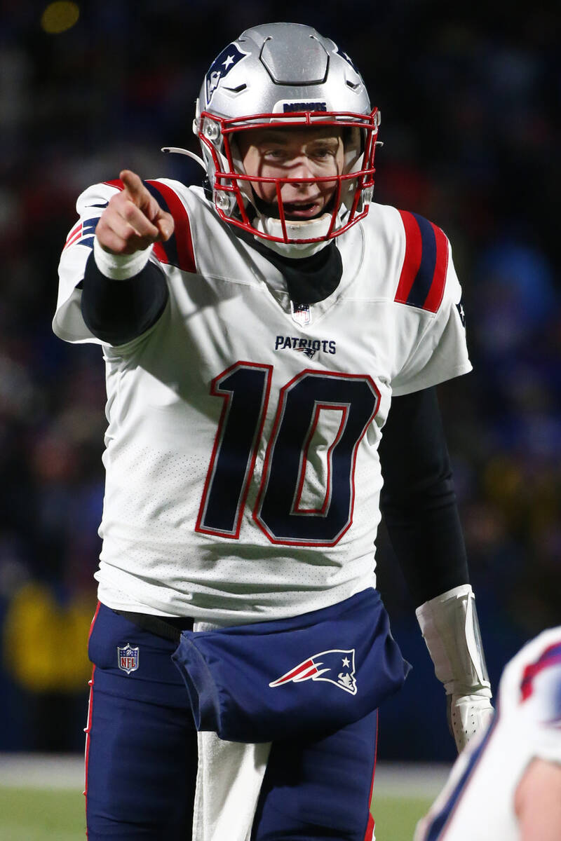 New England Patriots quarterback Mac Jones (10) points during the second half of an NFL wild-ca ...