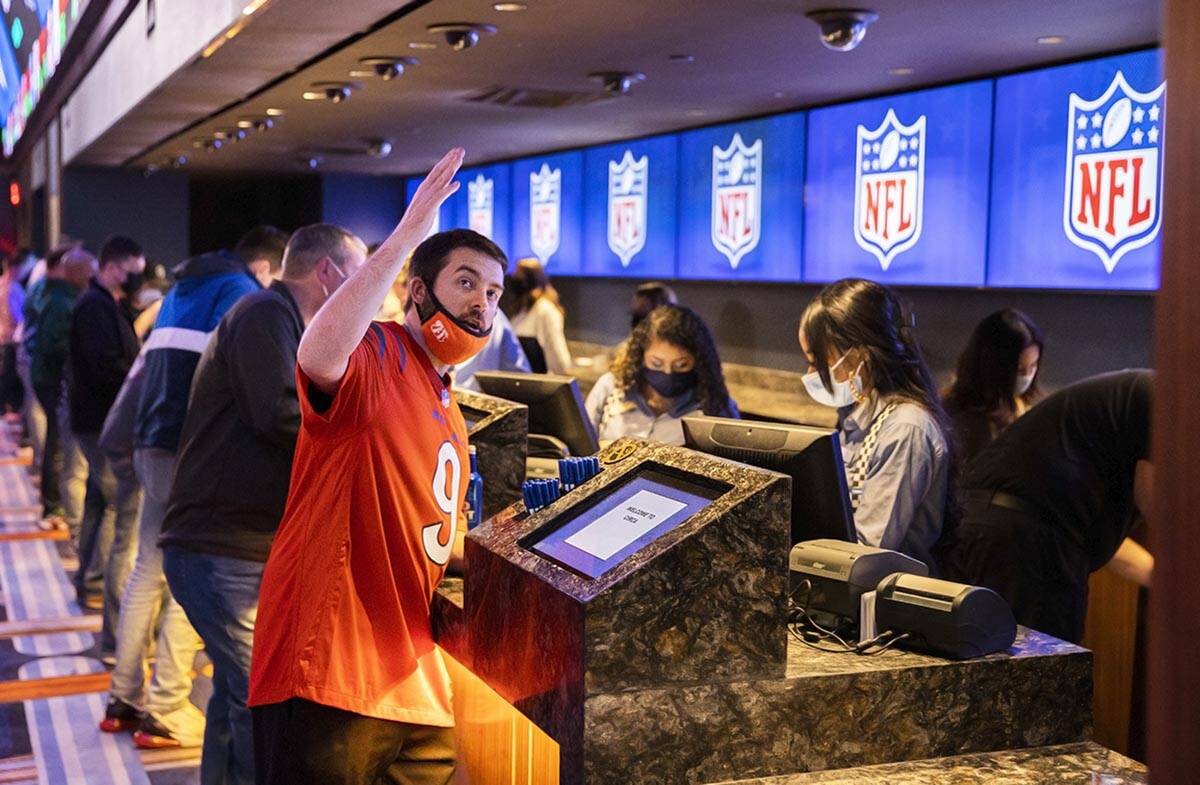 Jake Whitt, left, from Cincinnati, Ohio, places a bet before the start of the NFC Championship ...