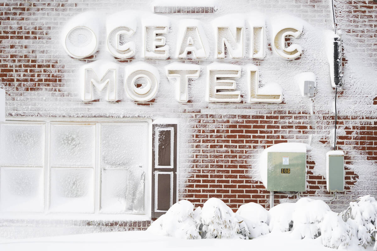 Signage outside of a motel is covered in snow, Saturday, Jan. 29, 2022, in Ocean City, Md. A po ...
