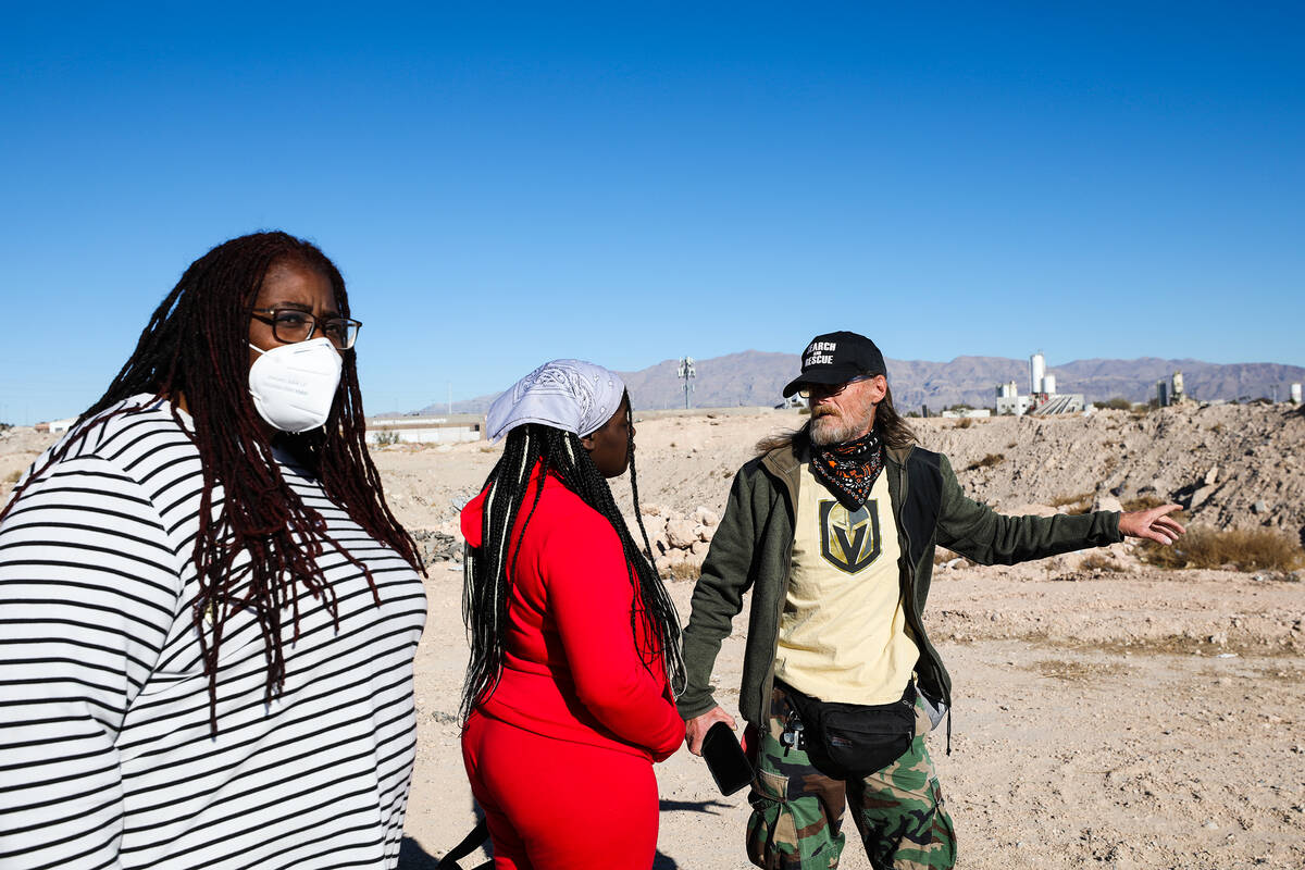 Kelly Winder, a local who volunteers with various dog rescue groups, far right, helps Tameka He ...