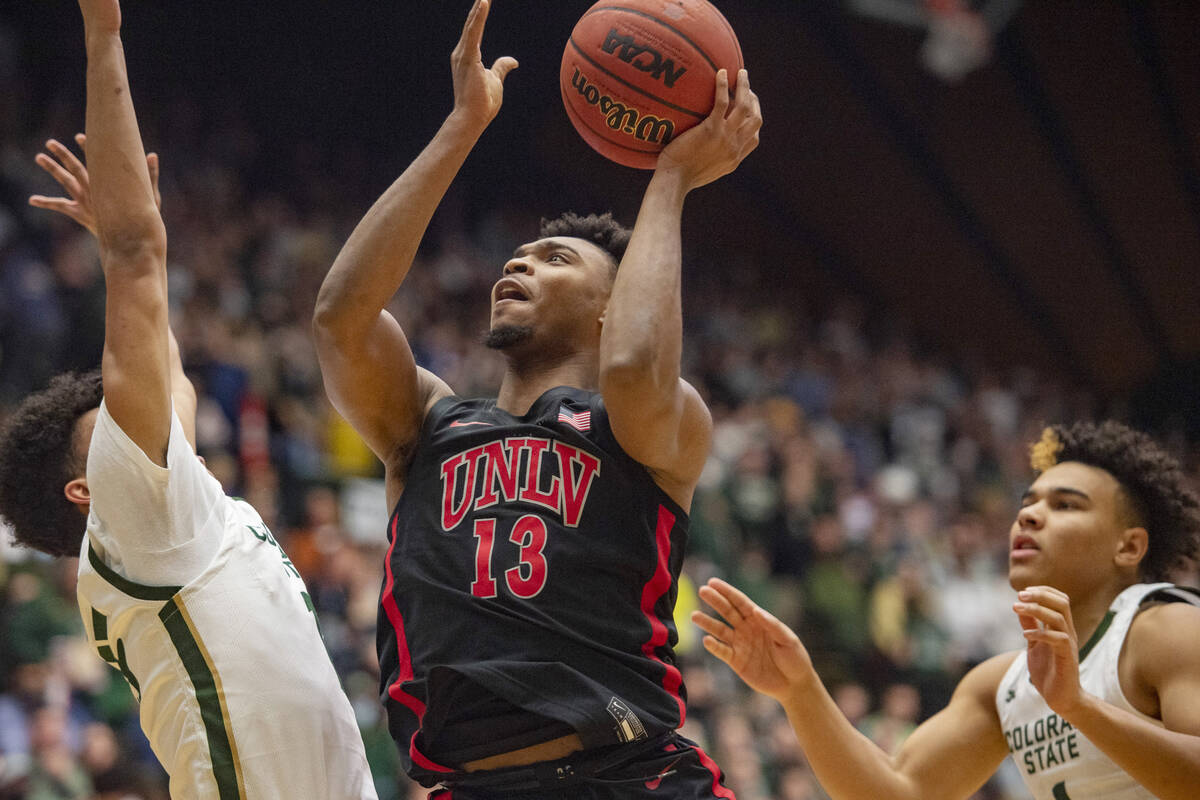 UNLV guard Bryce Hamilton, center, drives to the basket between Colorado State forward Jalen La ...