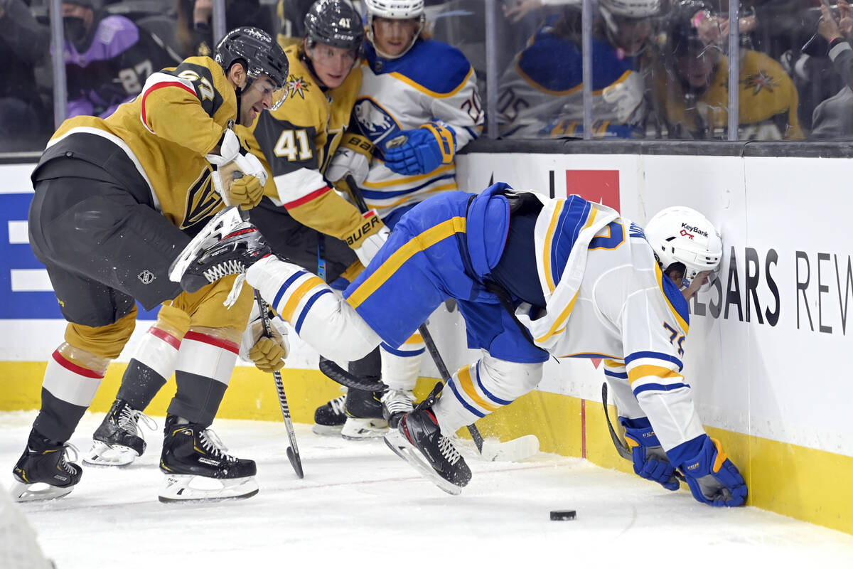Buffalo Sabres defenseman Jacob Bryson (78) is checked into the boards by Vegas Golden Knights ...