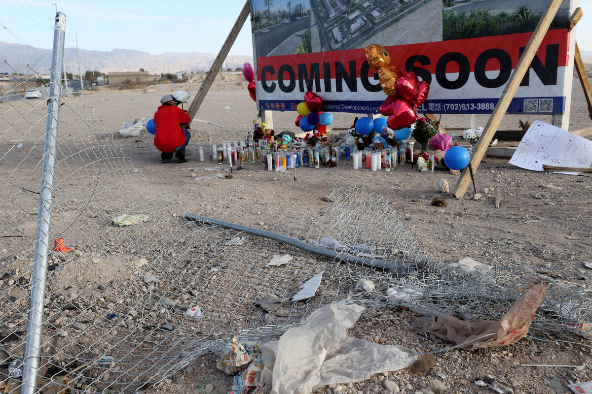 Jeanine Bright-Hooper of North Las Vegas places a flower at memorial to the victims of six-vehi ...