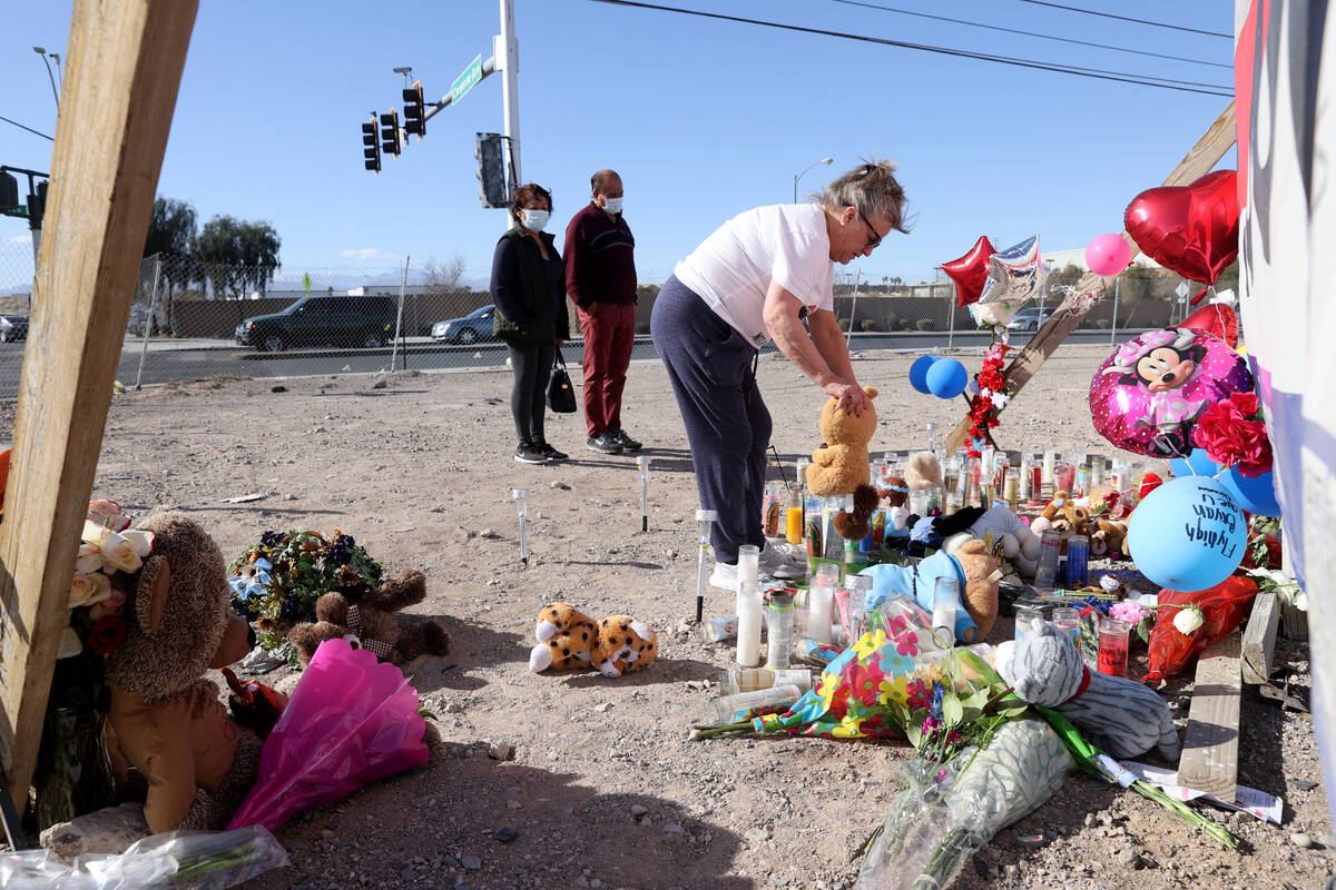 Diane Clawson of North Las Vegas replaces items that got blown over at memorial to the victims ...