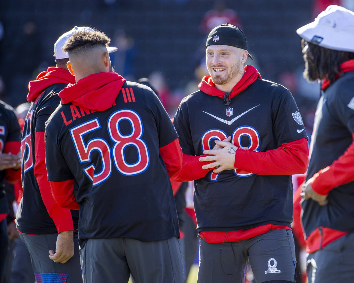 Raiders defensive end Maxx Crosby (98) talks with teammate Tennessee Titans linebacker Harold L ...