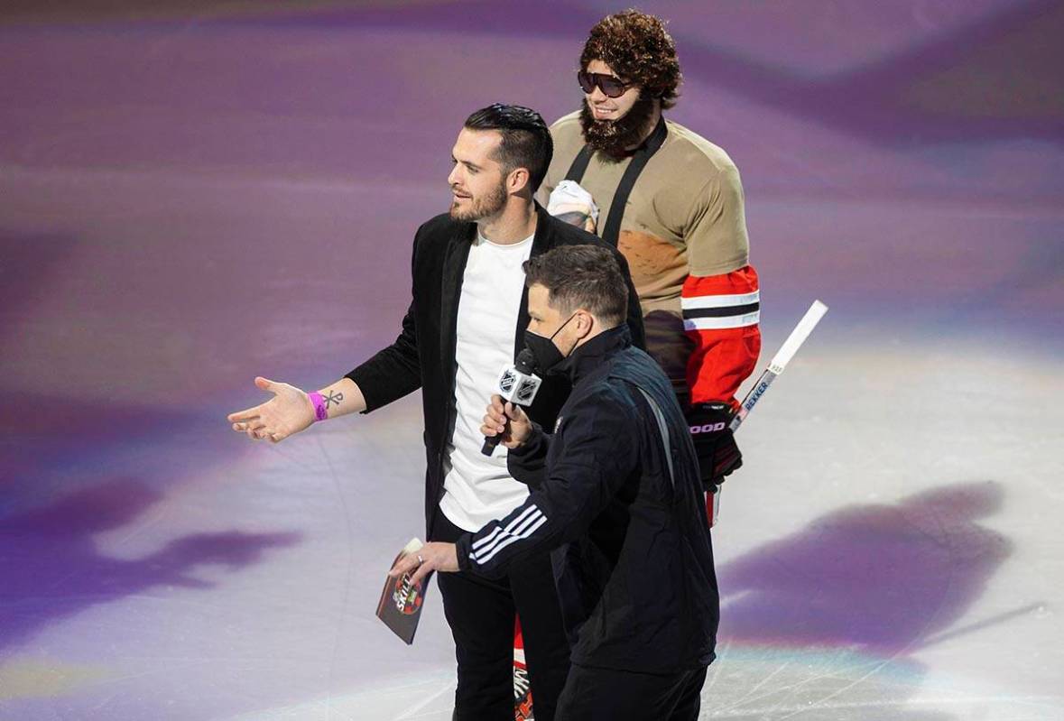 Chicago Blackhawks left wing Alex DeBrincat, top/right, Raiders quarterback Derek Carr and host ...