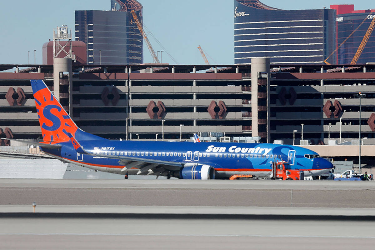 A Sun Country plane is towed away after making a hard landing at Harry Reid International Airpo ...