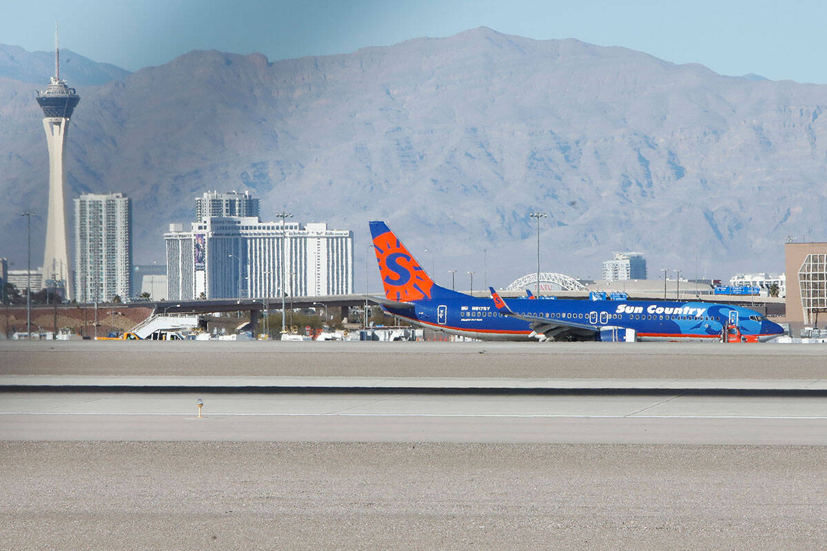 A Sun Country plane is towed away after making hard landing at Harry Reid International Airport ...