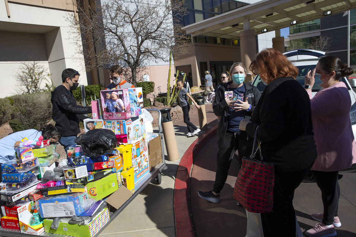 Payton Janney, third from left, child life specialist, receives a toy donation at Sunrise Child ...