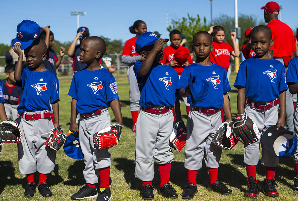 Members of the Blue Jays put their hats back on after the national anthem during the opening da ...