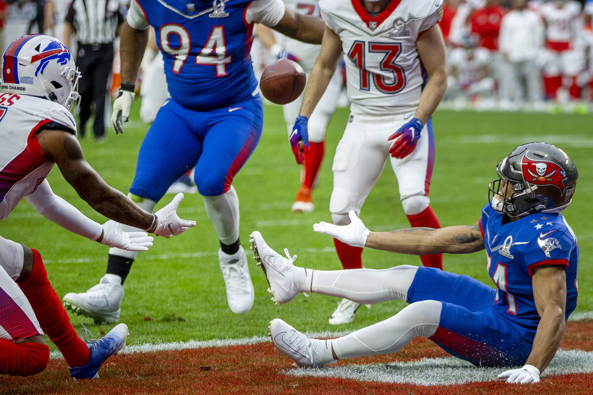 AFC receiver Stefon Diggs with the Buffalo Bills (14, left) looks to catch a reflection between ...