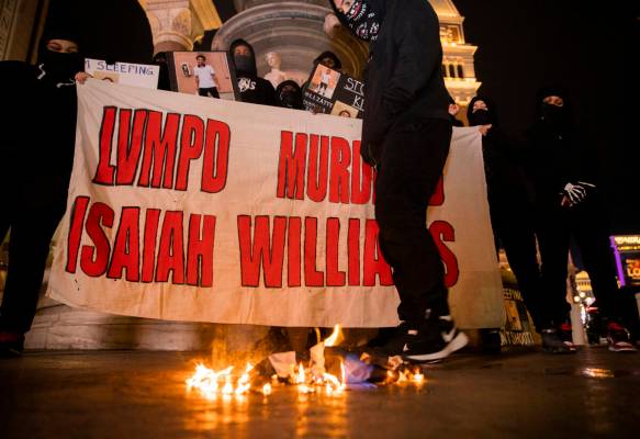 Protestors burn a police flag while demanding justice for Isaiah Williams, 19, who was shot and ...