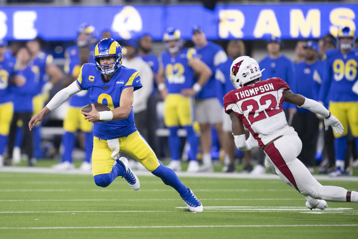 Los Angeles Rams quarterback Matthew Stafford (9) runs with the ball past Arizona Cardinals saf ...