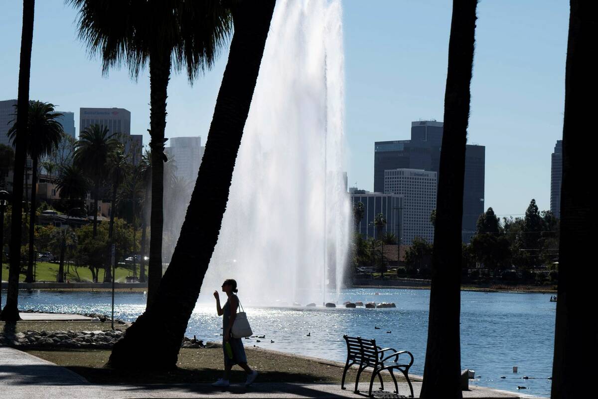 A visitor takes a stroll at Echo Park Lake in Los Angeles Wednesday, Feb. 9, 2022. (David Crane ...