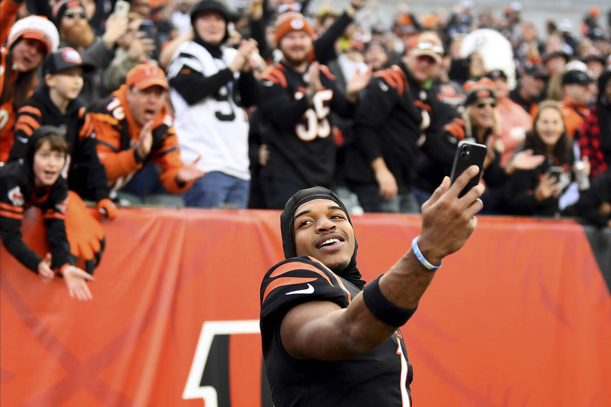 FILE - Cincinnati Bengals wide receiver Ja'Marr Chase (1) takes a video with fans in the backgr ...