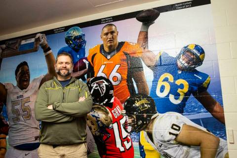 Former Reed High School football coach Ernie Howren poses next to a mural depicting former play ...