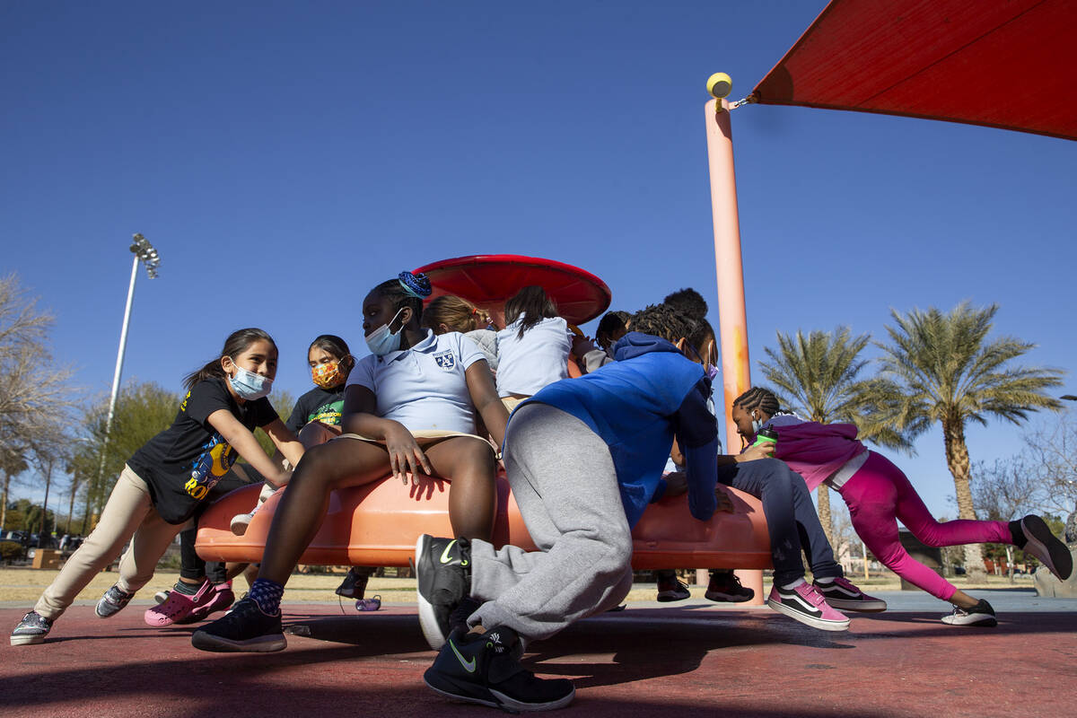 Children in the after-school program at Doolittle Community Center play on the merry-go-round o ...