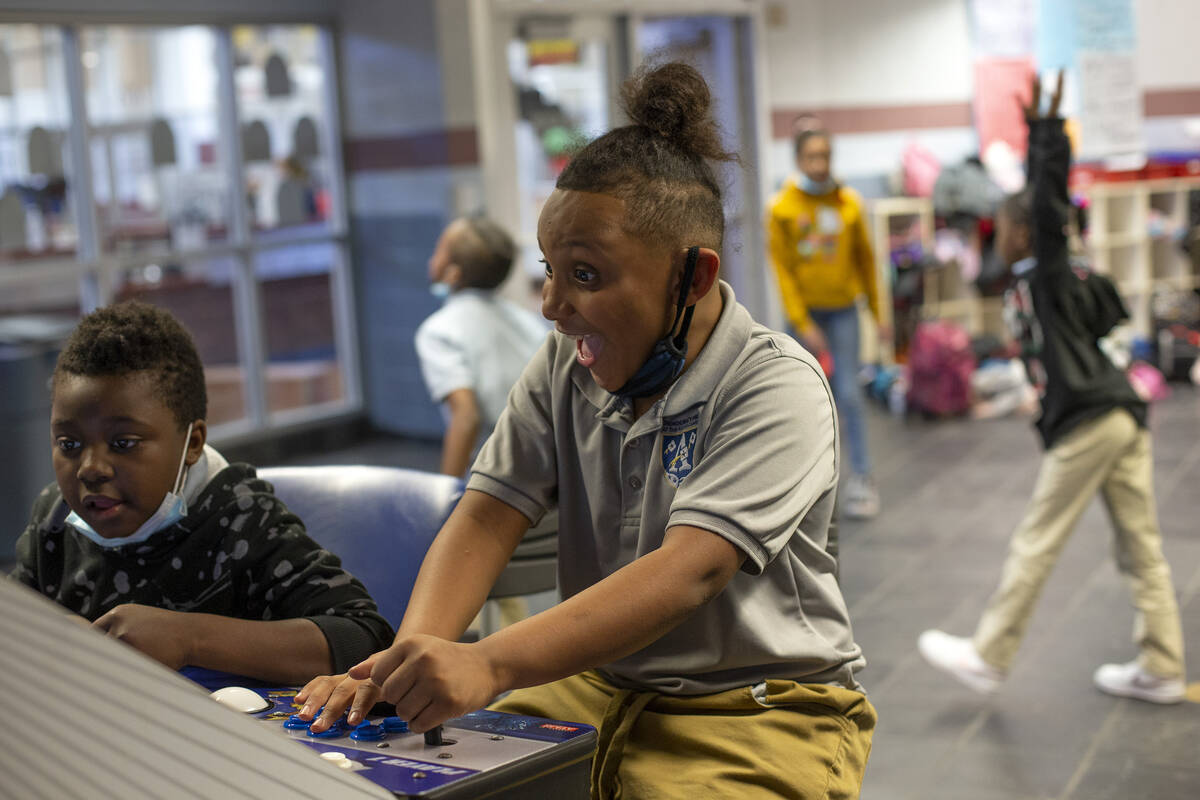 Izaiah Burnam, left, and Josiah Gill, center, play video games during the after-school program ...