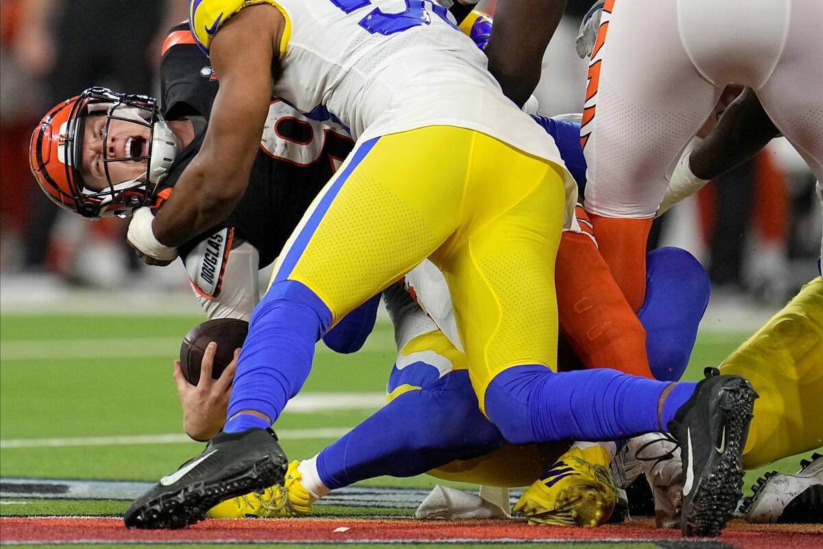 Cincinnati Bengals quarterback Joe Burrow, left, is sacked by Los Angeles Rams outside lineback ...