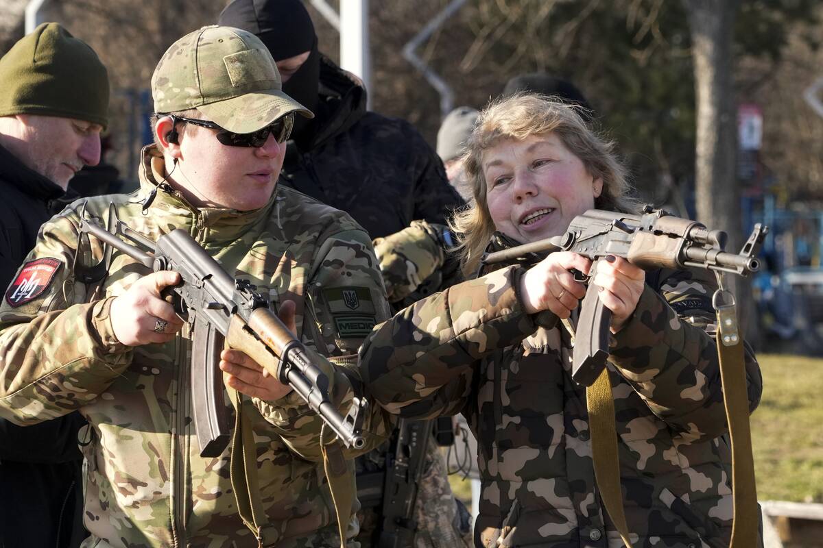 An instructor shows a woman how to use a Kalashnikov assault rifle, as members of a Ukrainian f ...