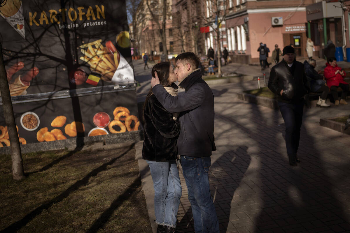 A couple kisses on a street in downtown Kyiv, Ukraine, Monday, Feb. 14, 2022. More NATO troops ...