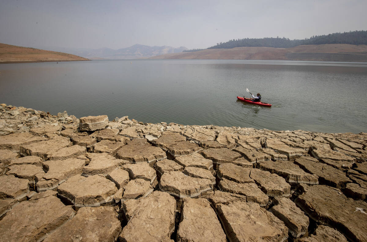 A kayaker paddles in Lake Oroville as water levels remain low due to continuing drought conditi ...