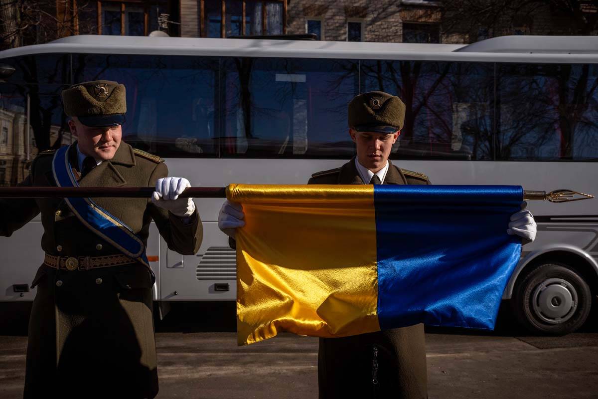 Honor guard soldiers fold an Ukraine flag following a ceremony to mark the anniversary of the w ...
