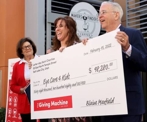 Stephanie Kirby with Eye Care 4 Kids, center, reacts to a check donation by Russ Cannon with Th ...