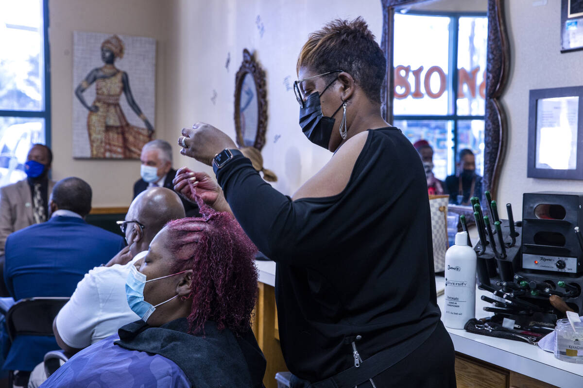 Illusion Salon of Beauty Torri Holliday, right, works on the hair of customer Tonya Price as Go ...