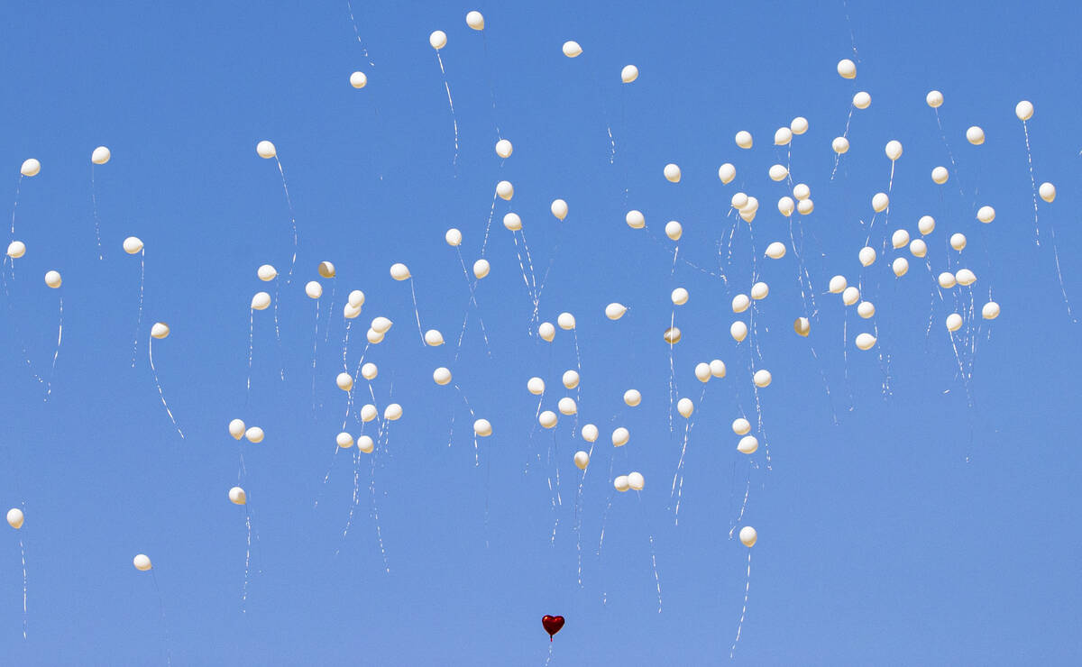 Balloons are released during the service and burial of members of the Zacarias family who were ...