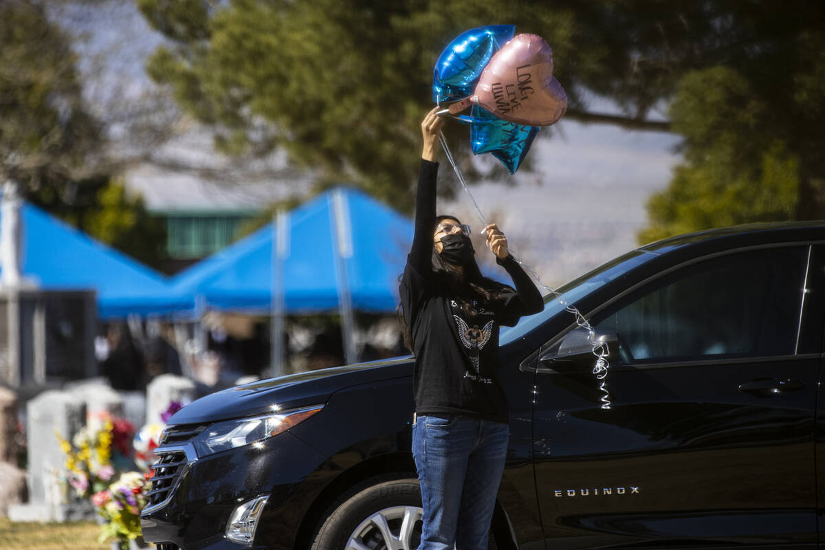 A woman releases balloons during the burial of the members of the Zacarias family, who were kil ...