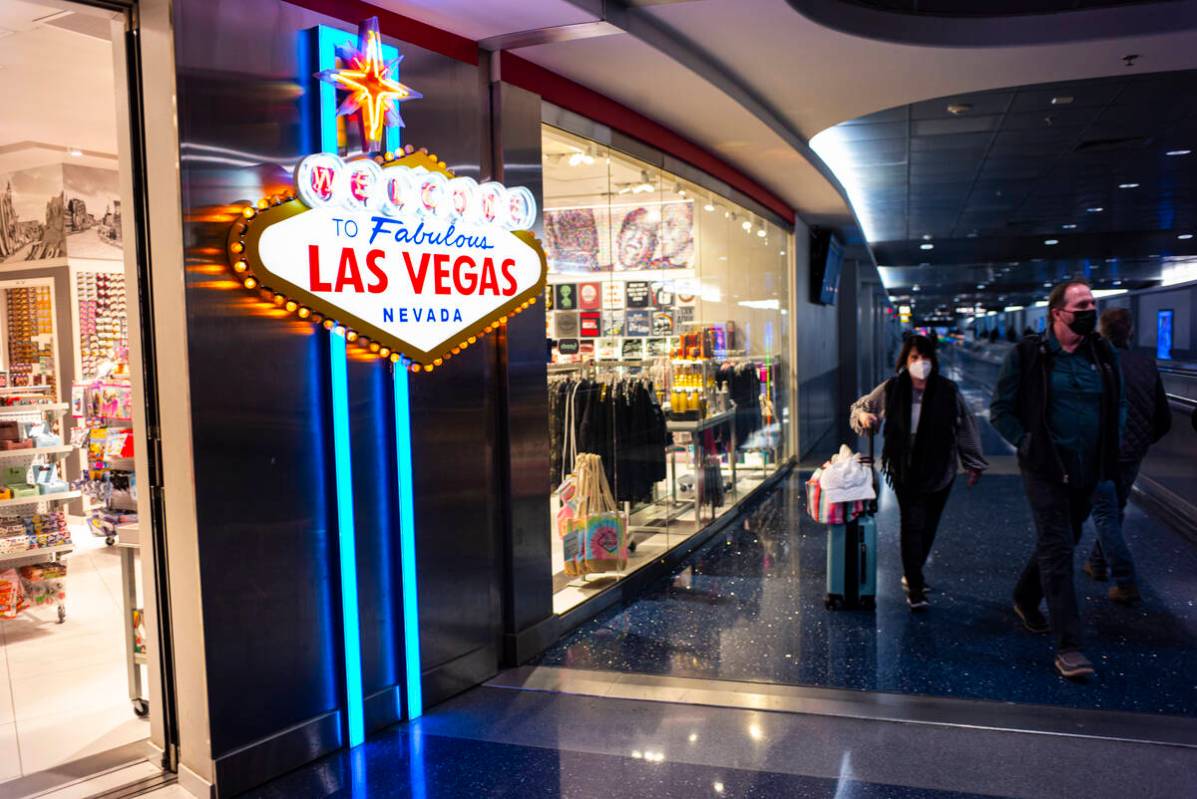 Travelers walk by in Terminal 1 at Harry Reid International Airport on Thursday, Jan. 13, 2022, ...