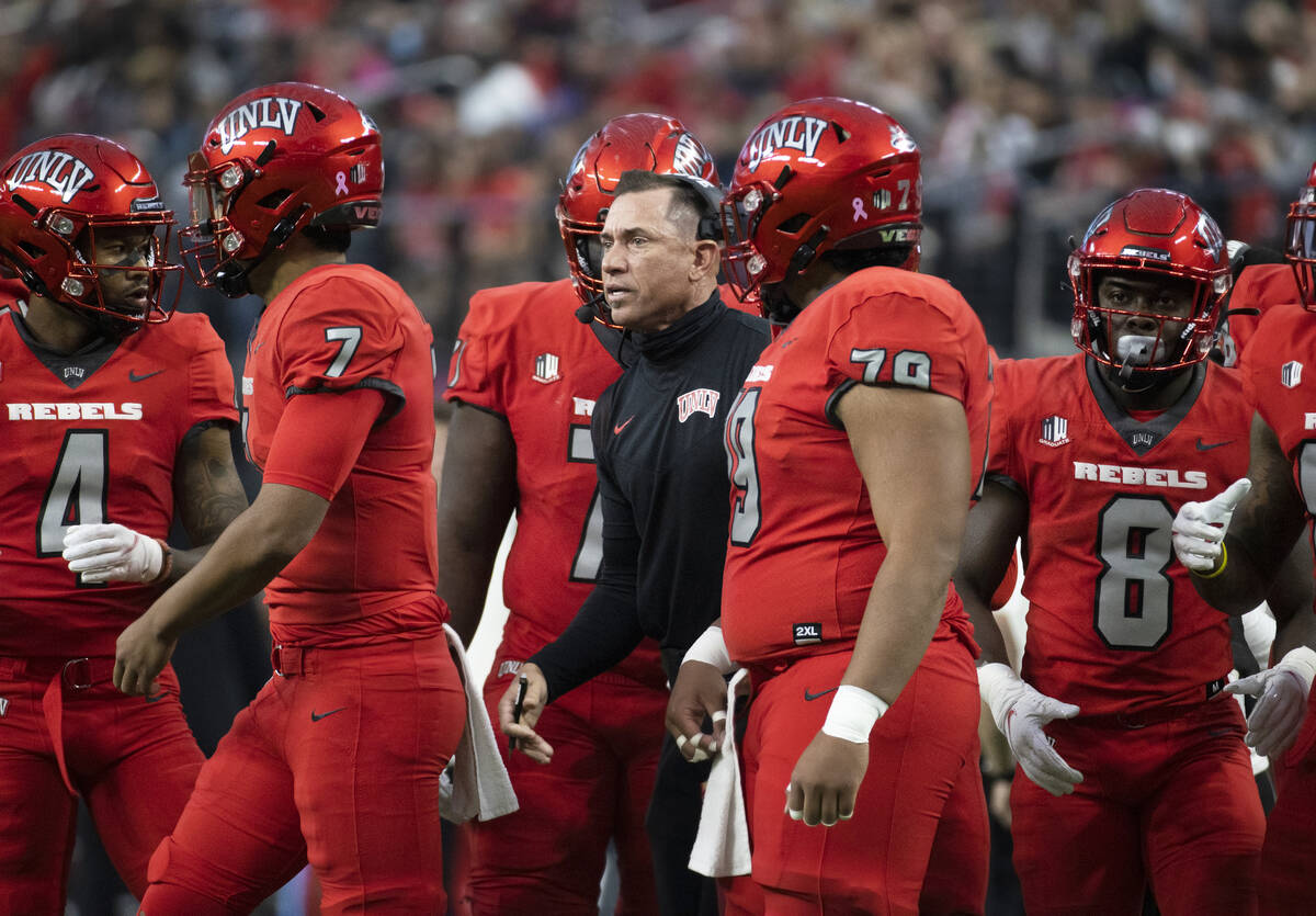 UNLV Rebels head coach Marcus Arroyo, middle, gives direction to his team during a time out in ...