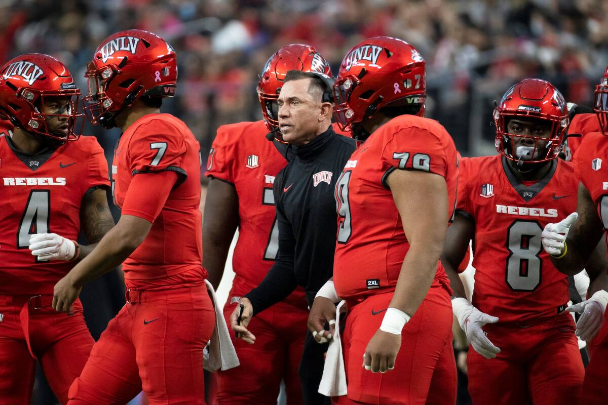 UNLV Rebels head coach Marcus Arroyo, middle, gives direction to his team during a time out in ...