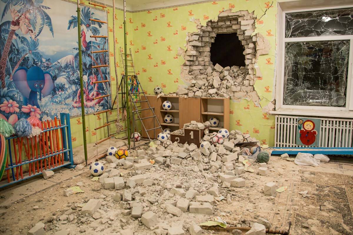 Bricks and debris mixes with toys below a damaged wall after the reported shelling on a kinderg ...