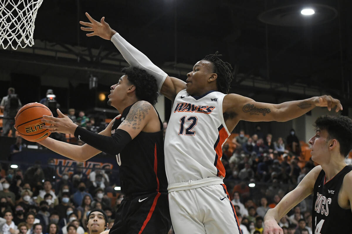 Gonzaga guard Julian Strawther (0) gets past Pepperdine forward Kendall Munson (12) for a shot ...