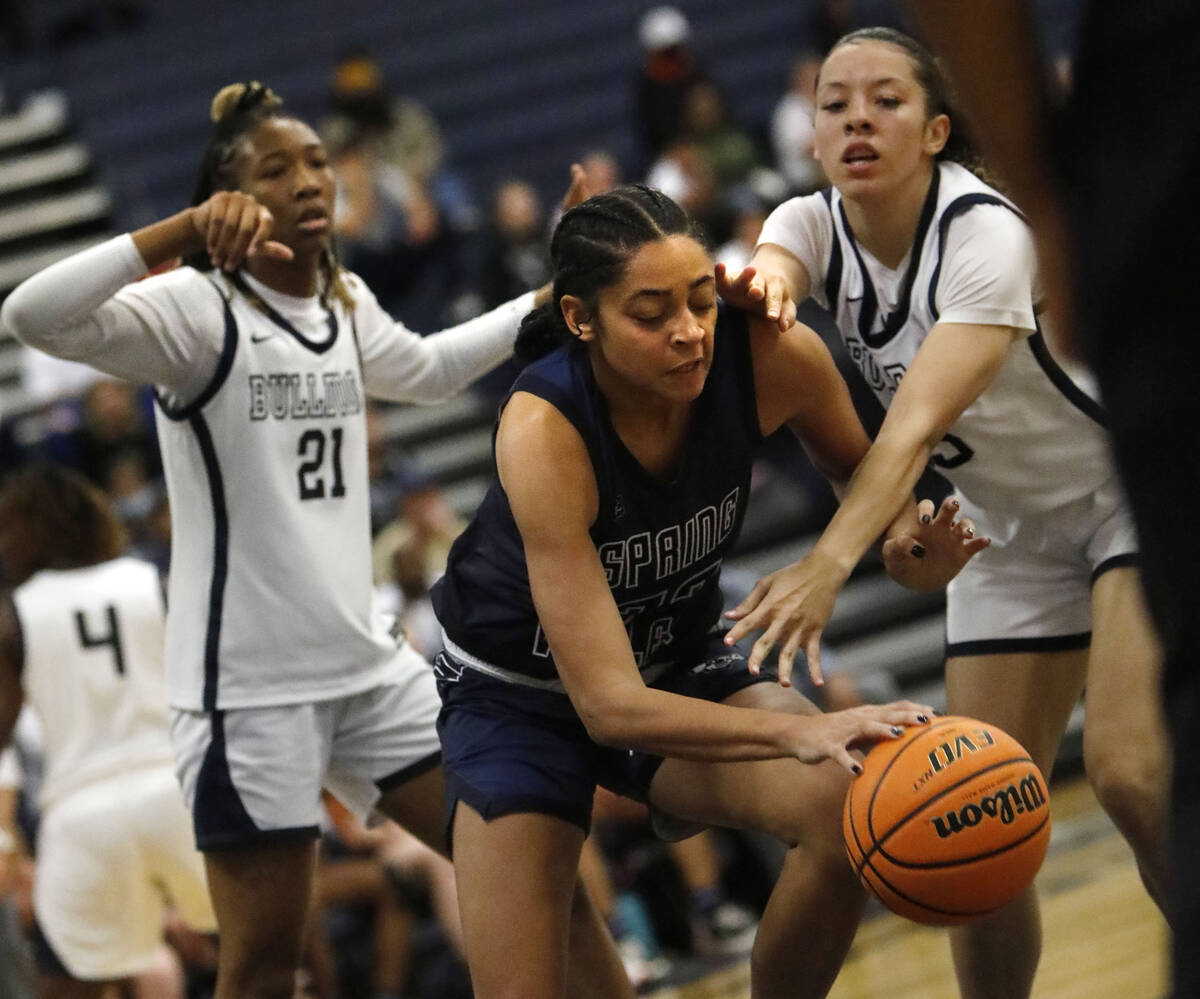 Spring Valley High School's Briana Green (33), center, keeps ball away from Centennial High Sch ...