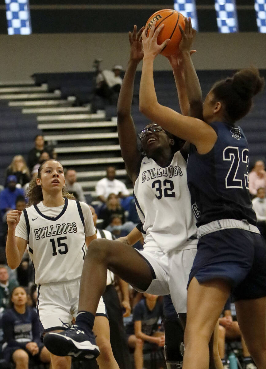 Centennial High School's Asani Ceaser (32) and Spring Valley High School's Jada Green (23) bat ...