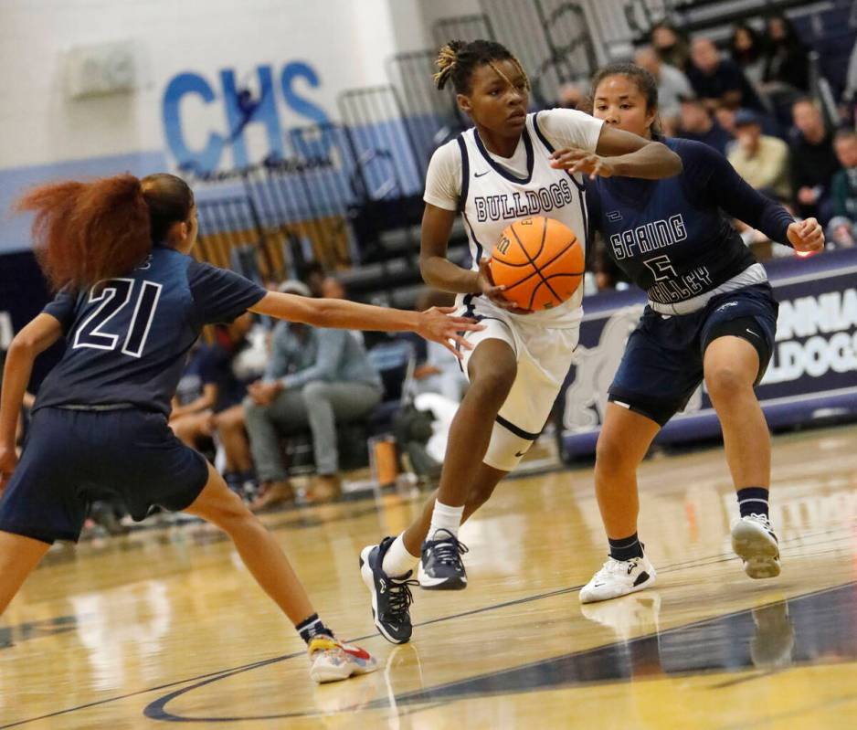 Centennial High School's Kaniya Boyd (00), center, tries to drive past Spring Valley High Schoo ...