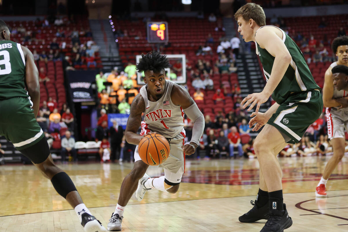 UNLV’s Michael Nuga (1) dribbles to the basket under pressure from Colorado State&#x2019 ...