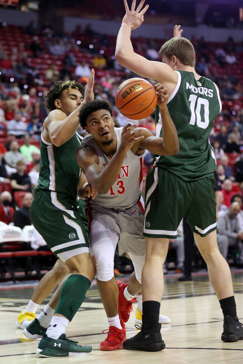 UNLV’s Bryce Hamilton (13) is pressured by Colorado State’s John Tonje (1) and Is ...