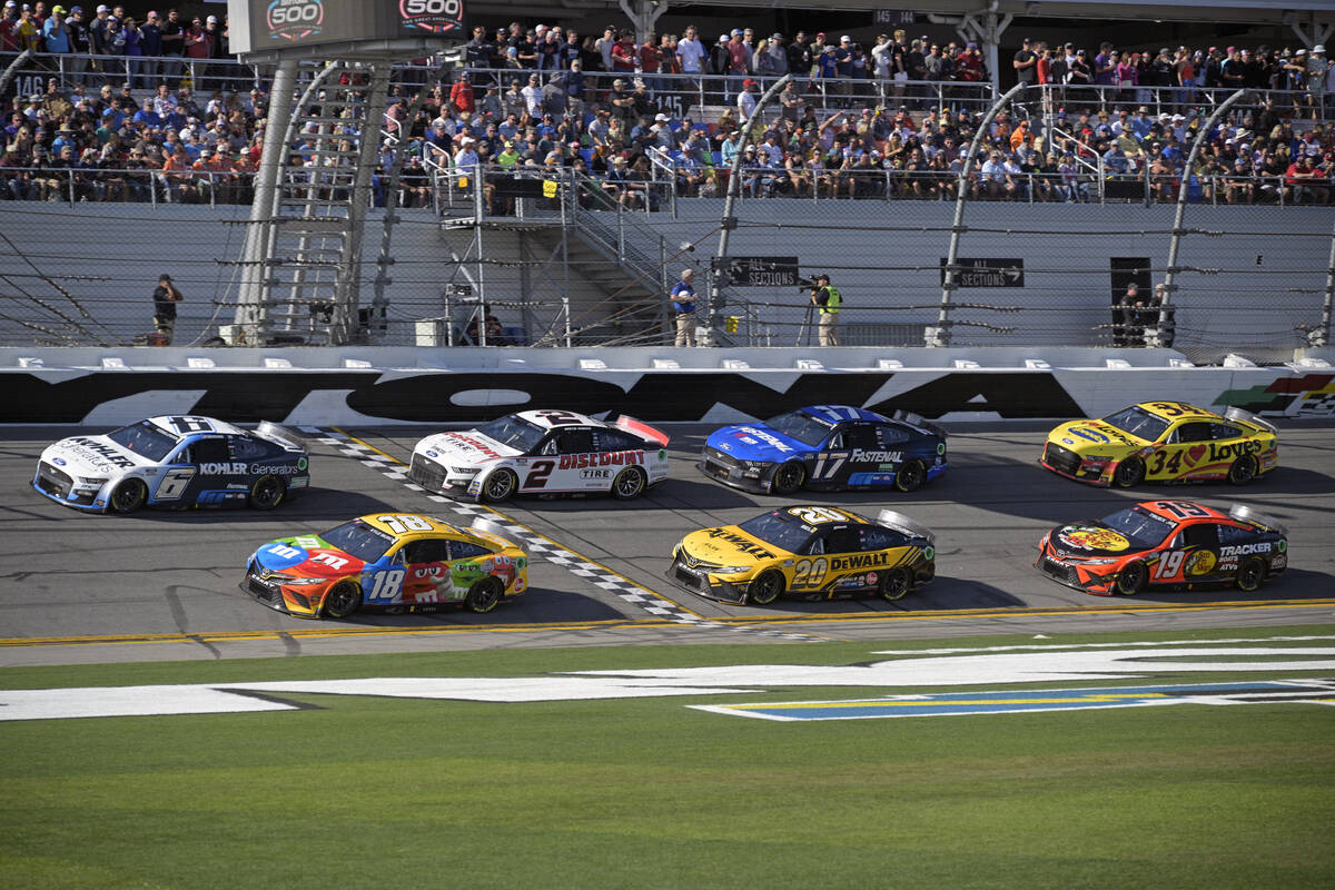 Brad Keselowski (6) and Kyle Busch (18) lead a pack through the front stretch during the NASCAR ...