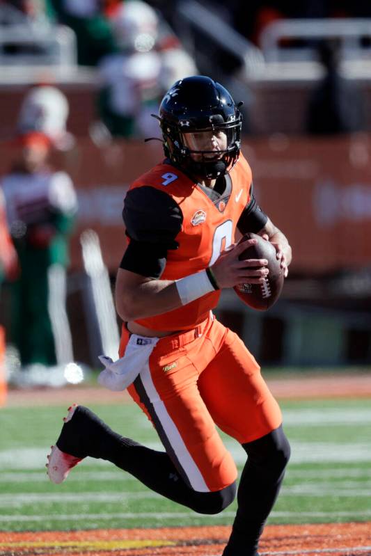 National Team quarterback Desmond Ridder of Cincinnati (9) carries the ball in an NCAA college ...