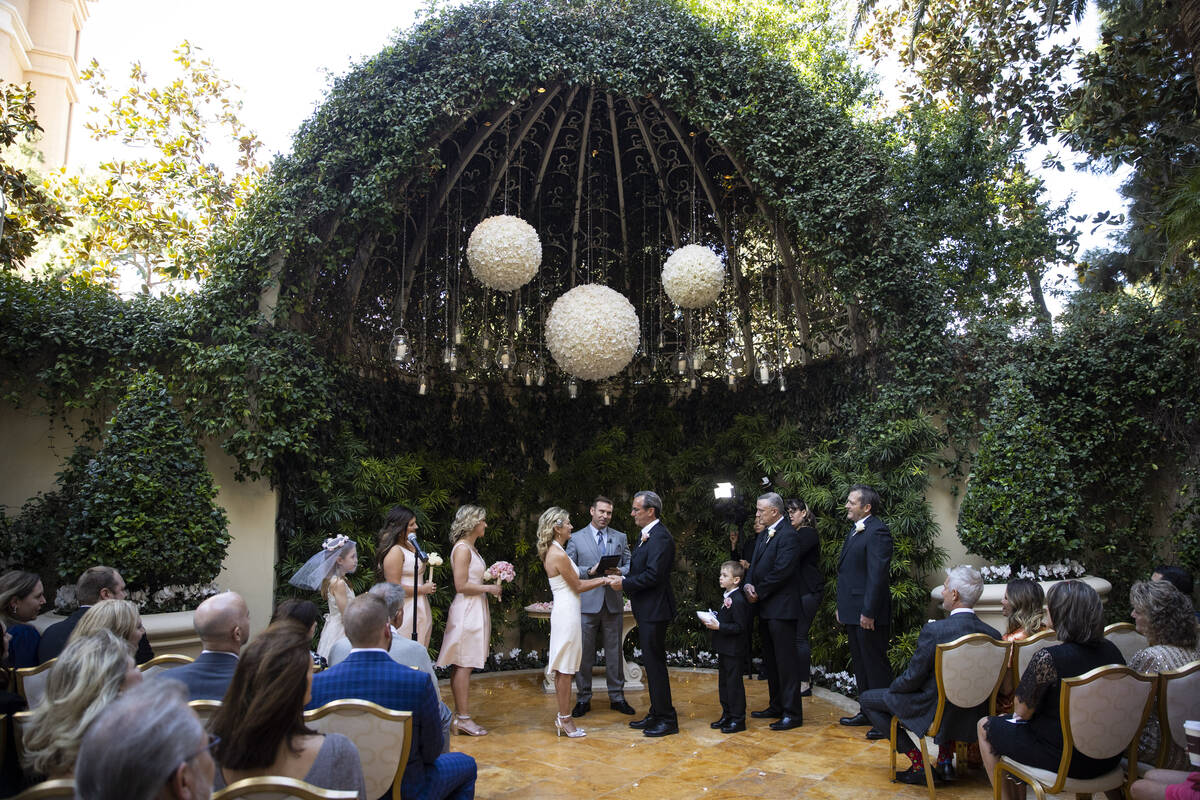 Sheila Daley, left, and James Dunbar, hold hands during their wedding ceremony at the Wynn hote ...