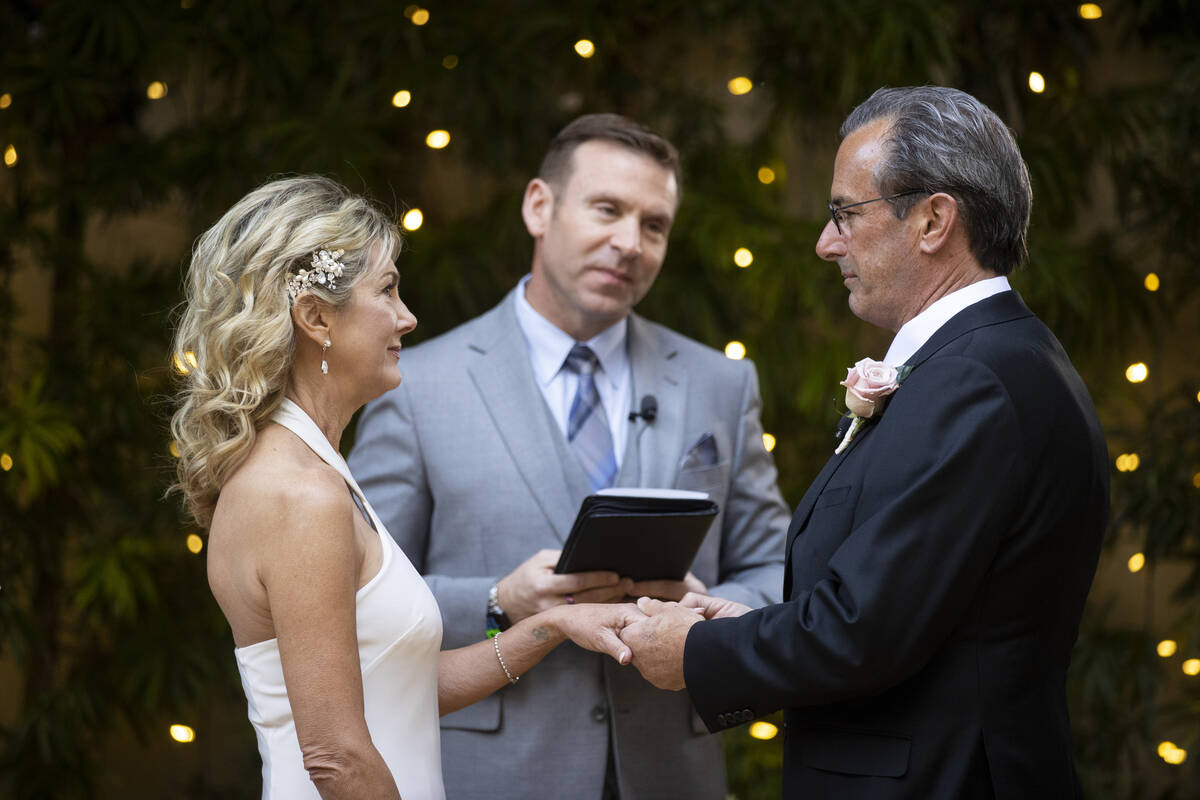 Wedding officiant Michael Engfer, center, leads the wedding ceremony for Sheila Daley, left, an ...