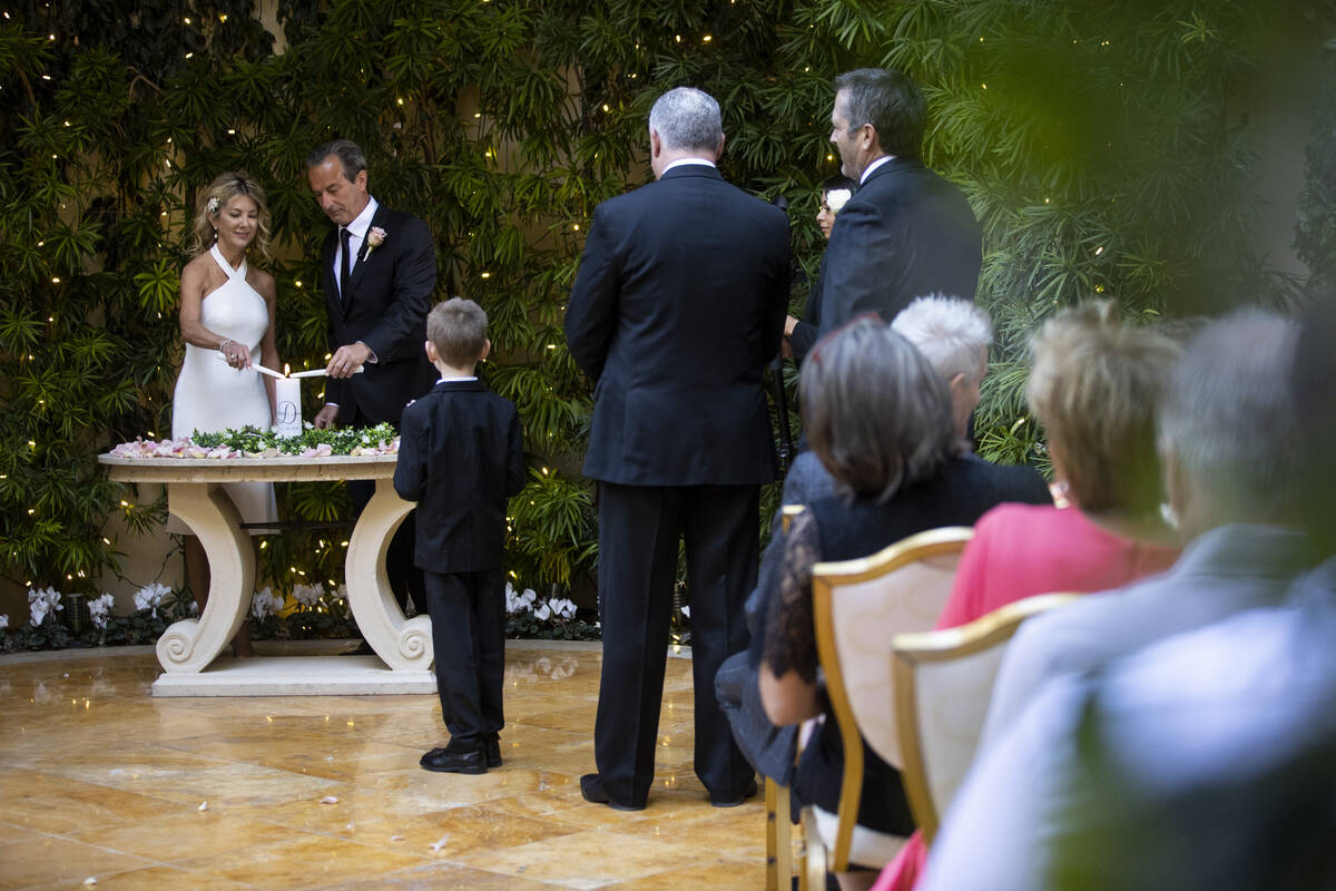 Sheila Daley, left, and James Dunbar, light up their unity candle during their wedding ceremony ...